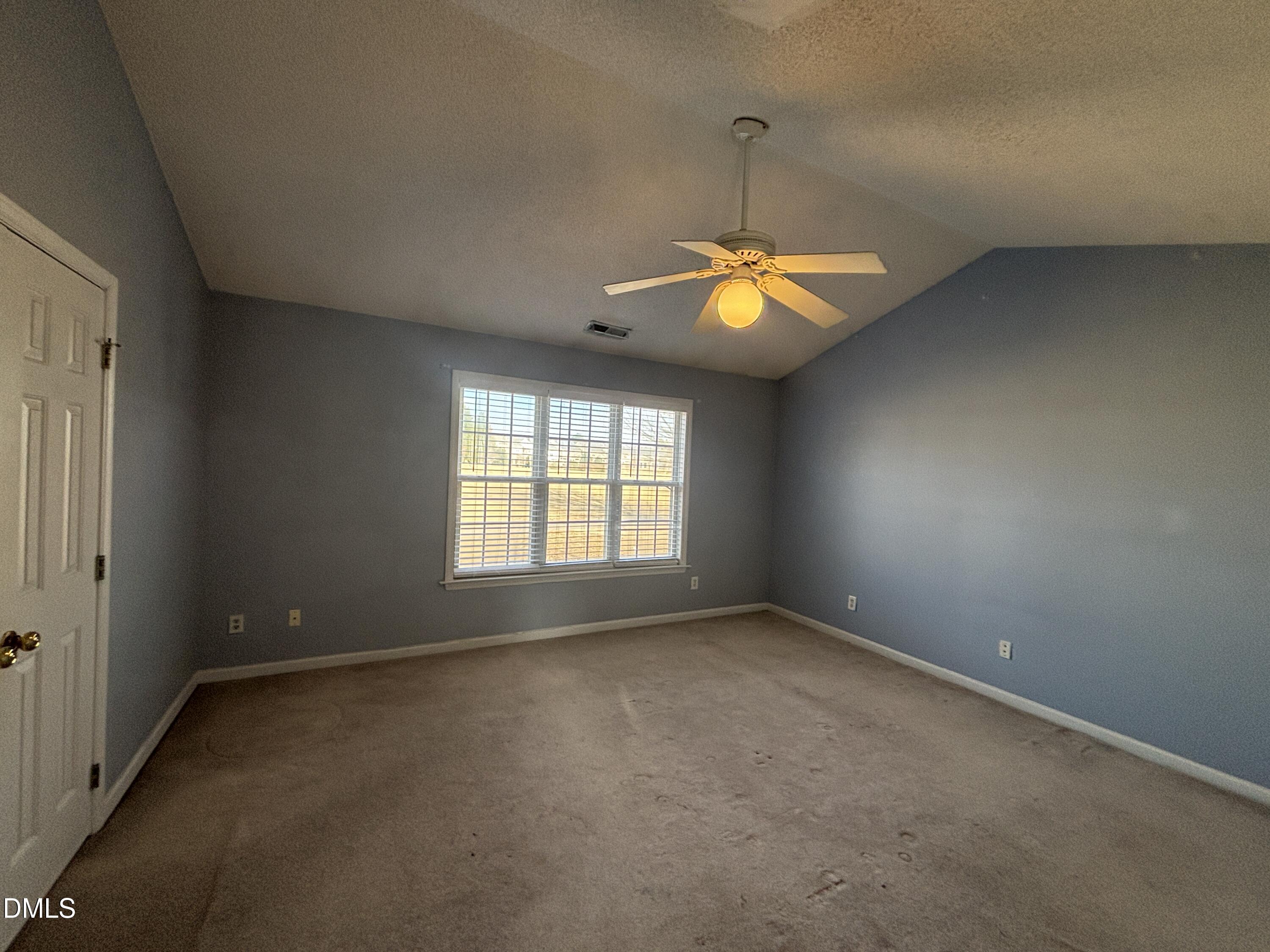 1704 Crag Burn Lane Raleigh, NC 27604 - Photo 17 of 22 an empty room with a chandelier fan and window