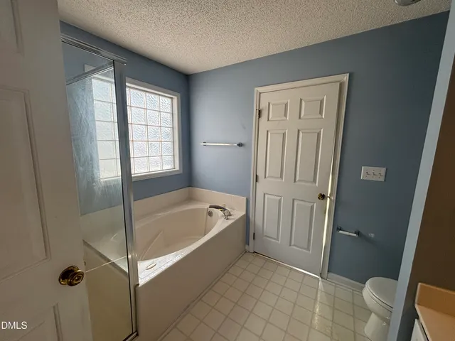 a bathroom with a tub a toilet and a sink