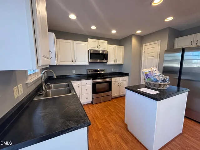 a kitchen with stainless steel appliances granite countertop a stove a sink and a microwave