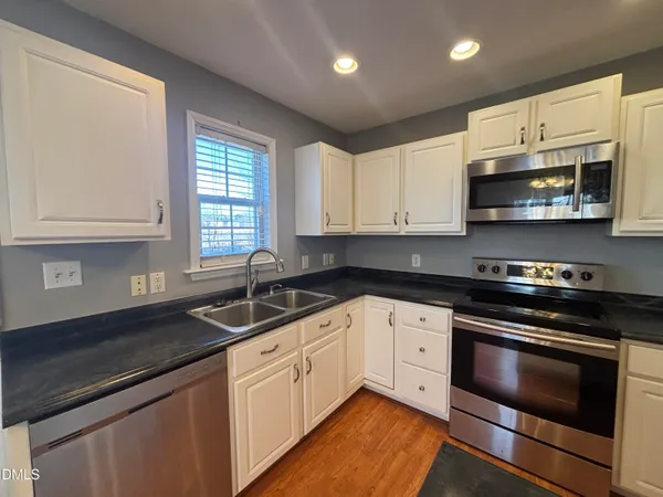 a kitchen with stainless steel appliances granite countertop a sink stove and microwave