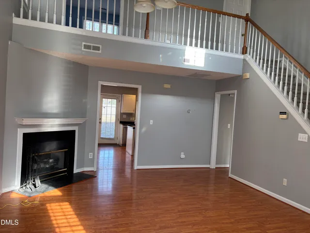 a view of livingroom with fireplace wooden floor and stairs