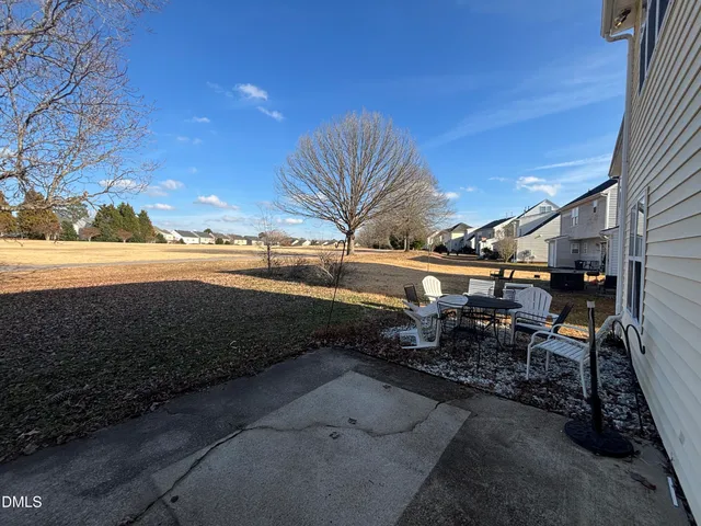 a view of a backyard with table and chairs