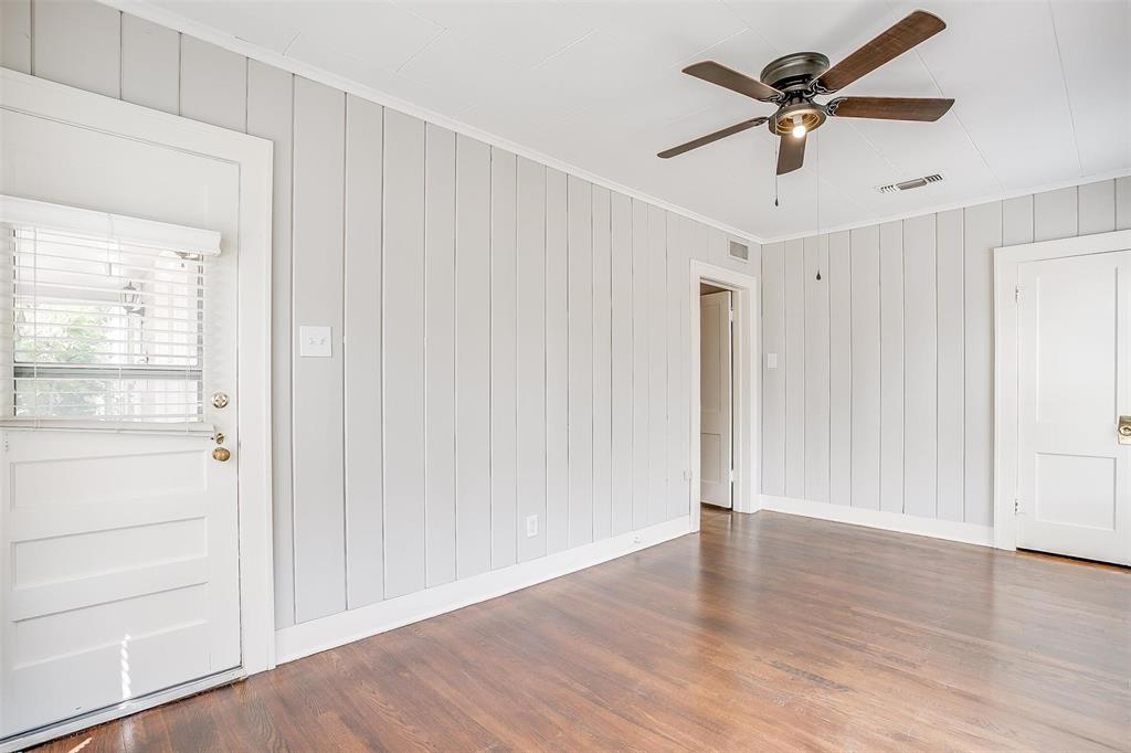 3140 Rogers Avenue, Unit 3142 Fort Worth, TX 76109 - Photo 5 of 13 an empty room with wooden floor chandelier fan and windows