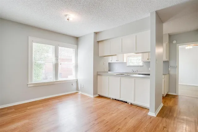 a kitchen with granite countertop white cabinets and wooden floor