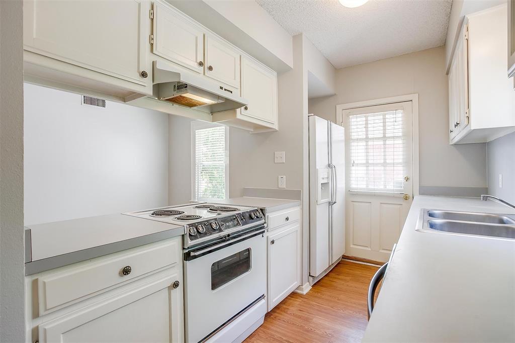 3140 Rogers Avenue, Unit 3142 Fort Worth, TX 76109 - Photo 8 of 13 a kitchen with stainless steel appliances white cabinets and a window