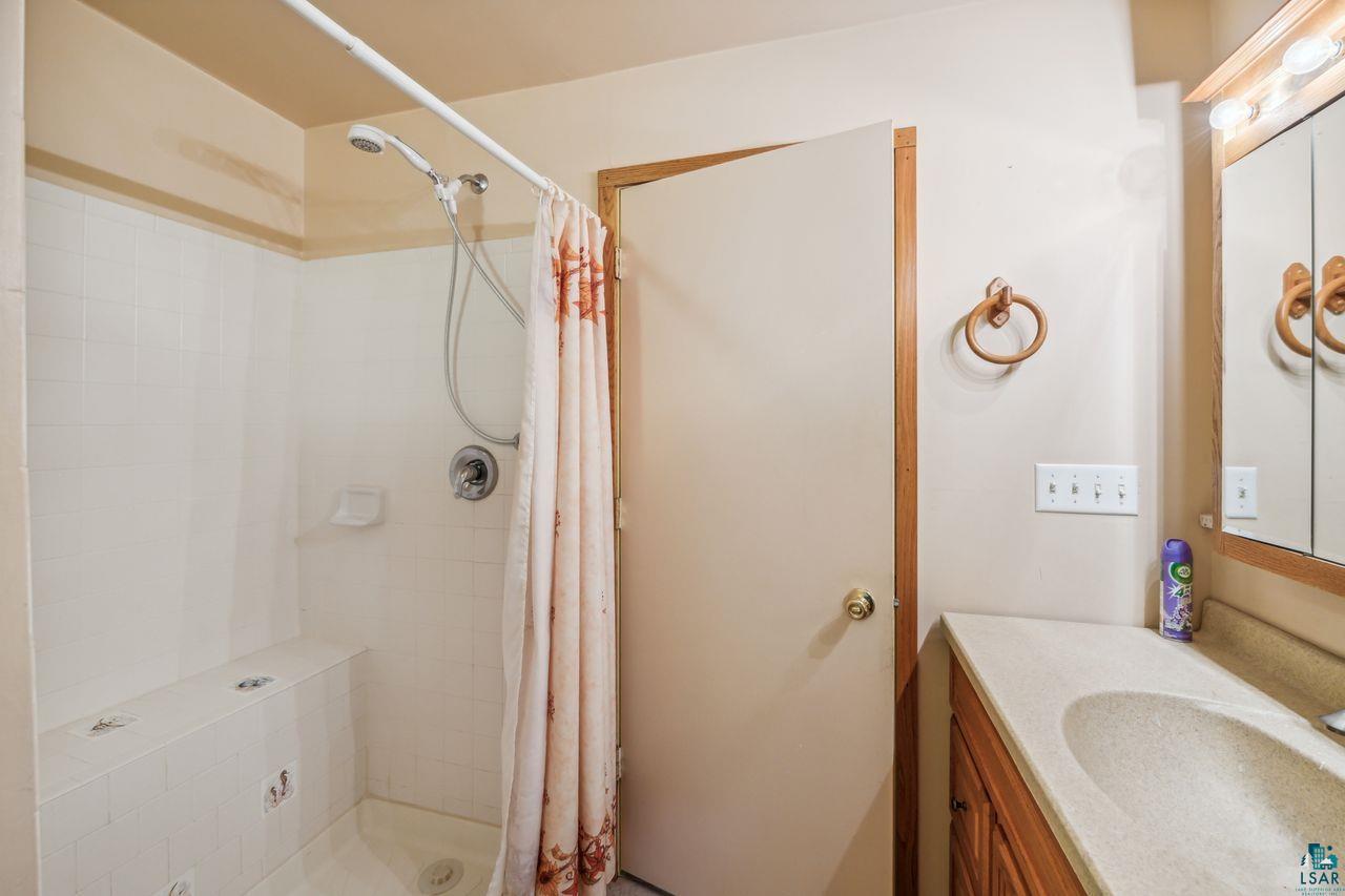 55675 Ashland Bayfield Road Mason, WI 54856 - Photo 11 of 26 Bathroom with curtained shower and vanity