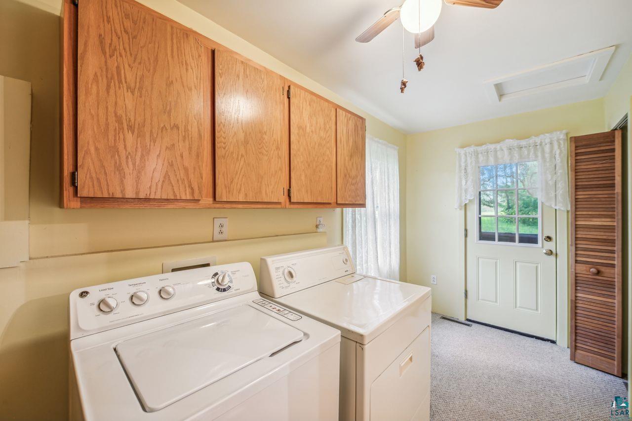 55675 Ashland Bayfield Road Mason, WI 54856 - Photo 9 of 26 Laundry room with ceiling fan, washer and clothes dryer, light colored carpet, and cabinets