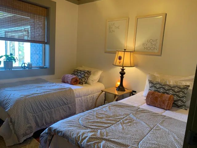 a bedroom with two beds and painting on the wall