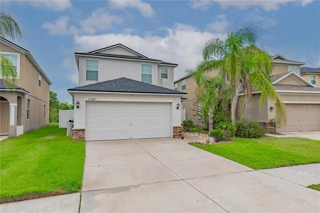 a front view of a house with a yard and garage