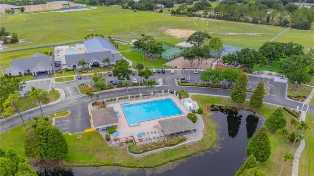 an aerial view of a house with a garden and lake view