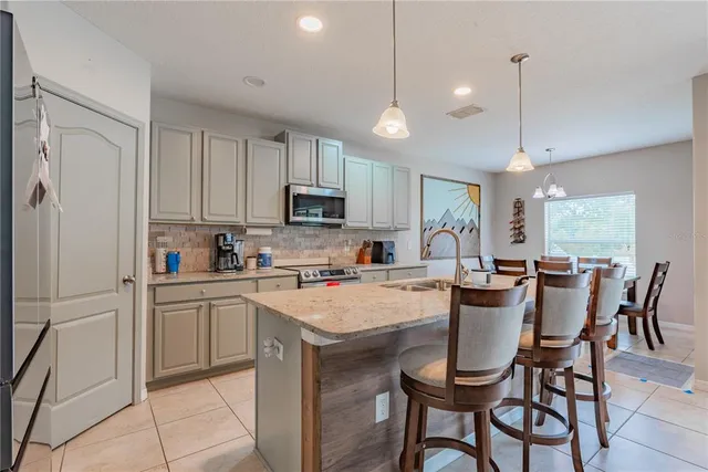 a kitchen with stainless steel appliances granite countertop a sink a stove and a refrigerator