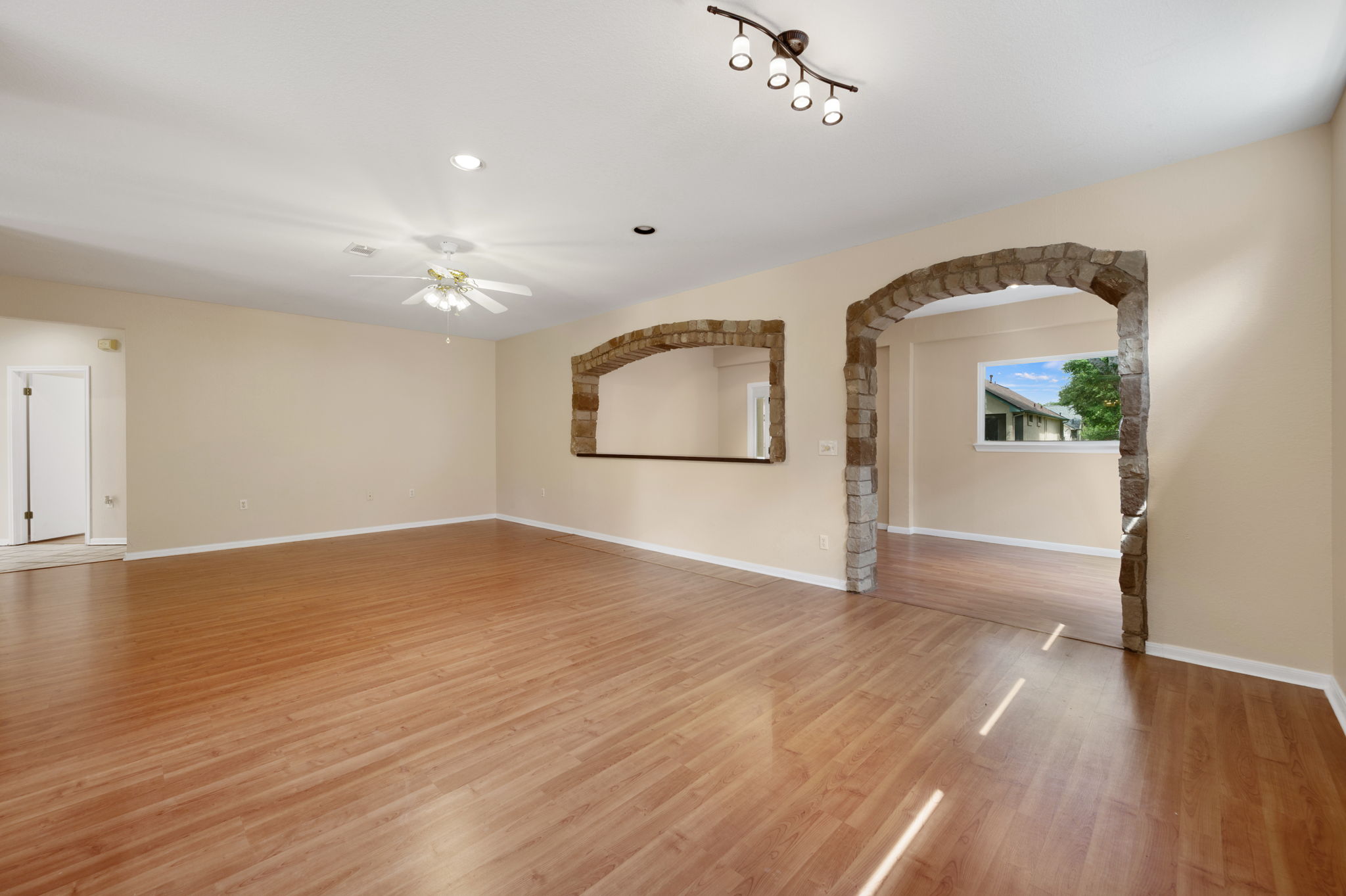 118 Bass Street Georgetown, TX 78633 - Photo 14 of 40 Stone archways frame an inviting living space with light-colored flooring.