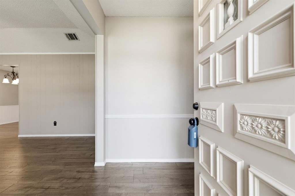 6612 Patsy Lane Watauga, TX 76148 - Photo 3 of 32 Entryway with decorative paneled door and wood-finish flooring