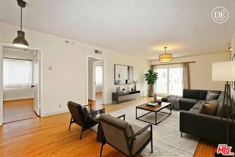 a living room with furniture and a wooden floor