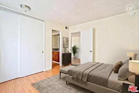 a bedroom with a bed and wooden floor