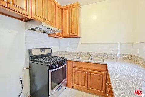 a kitchen with stainless steel appliances granite countertop a sink stove and cabinets