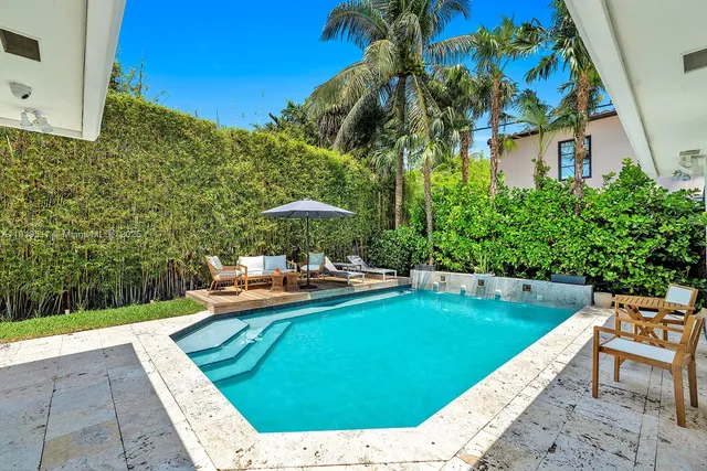 a view of a patio with chairs and an umbrella