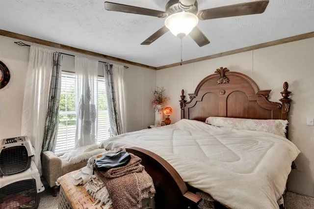 a bedroom with a bed dresser and a window