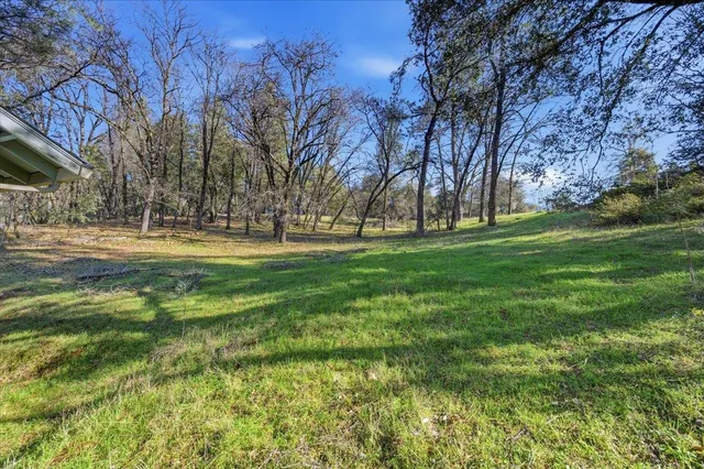 an aerial view of house with yard and mountain view in back