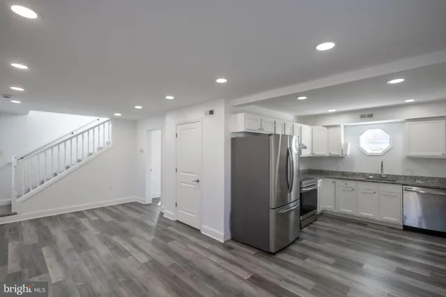 a kitchen with stainless steel appliances granite countertop a refrigerator and a stove top oven