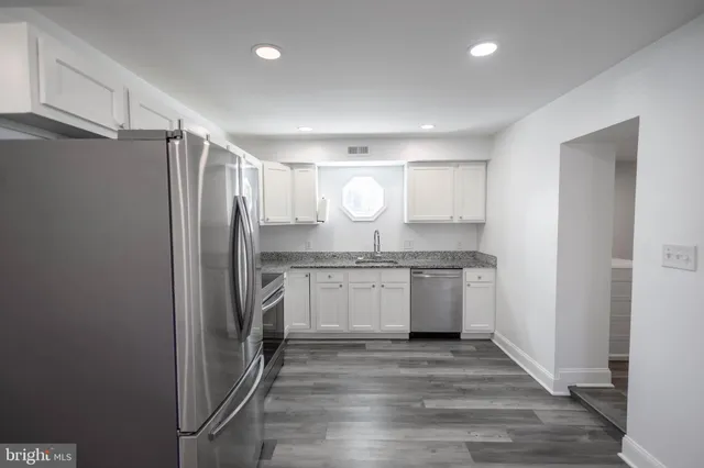 a kitchen with a refrigerator sink and cabinets