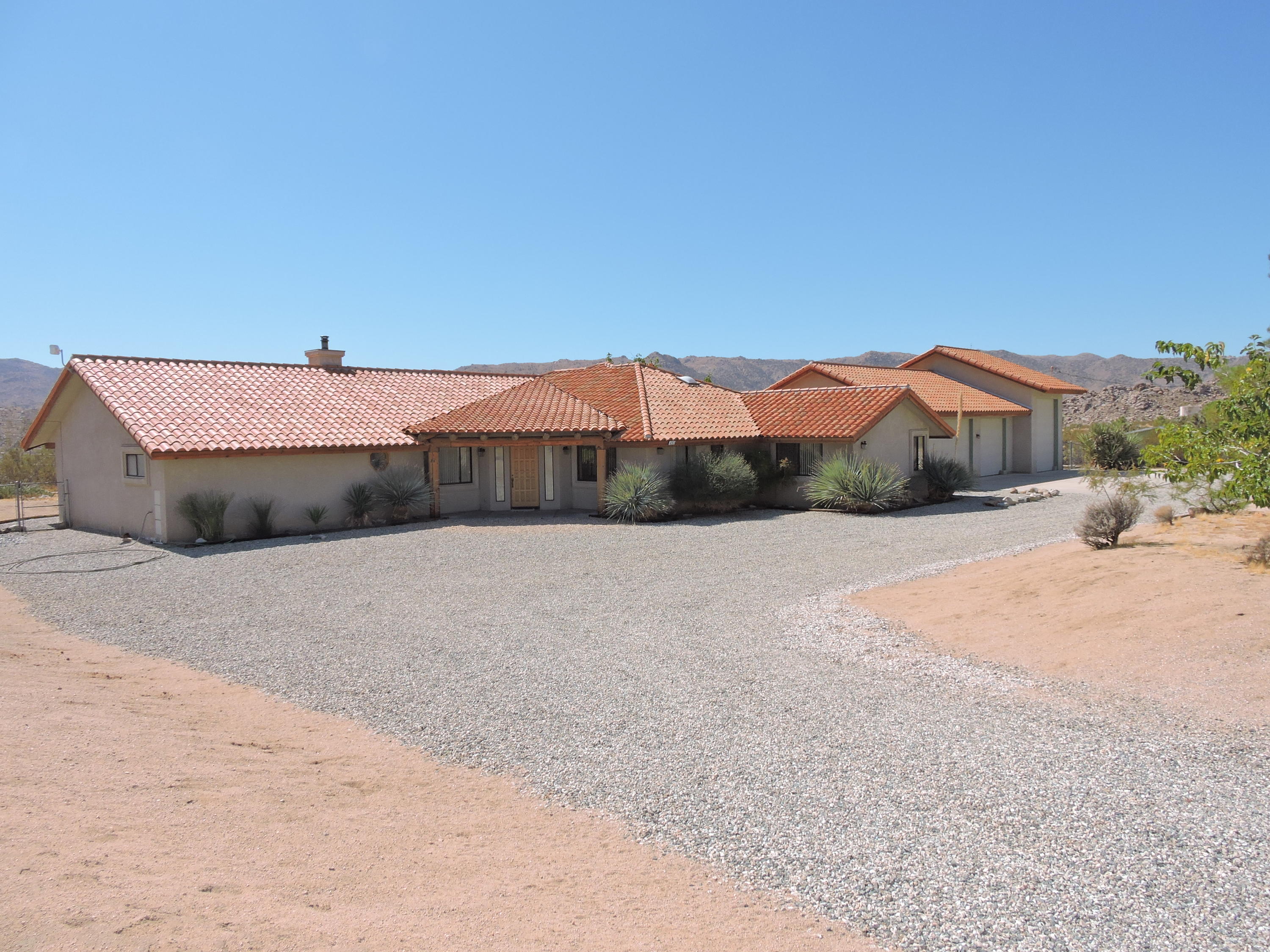63533 Wagon Wheel Road Joshua Tree, CA 92252 - Photo 4 of 62 a front view of a house with a yard