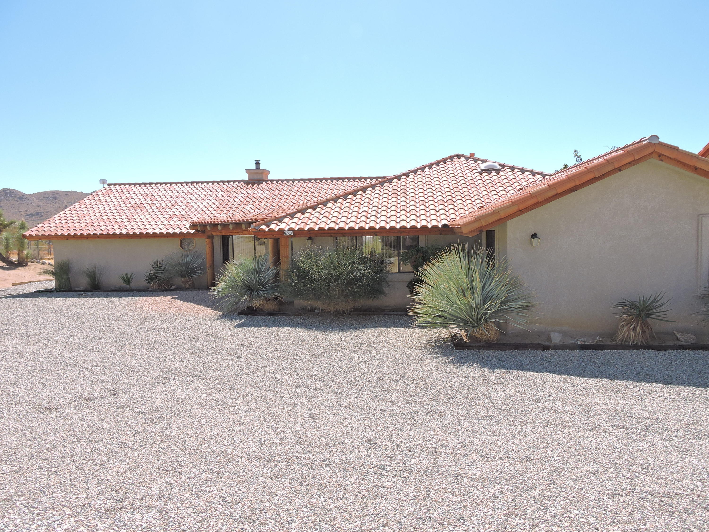 63533 Wagon Wheel Road Joshua Tree, CA 92252 - Photo 55 of 62 a palm tree sitting in front of a house