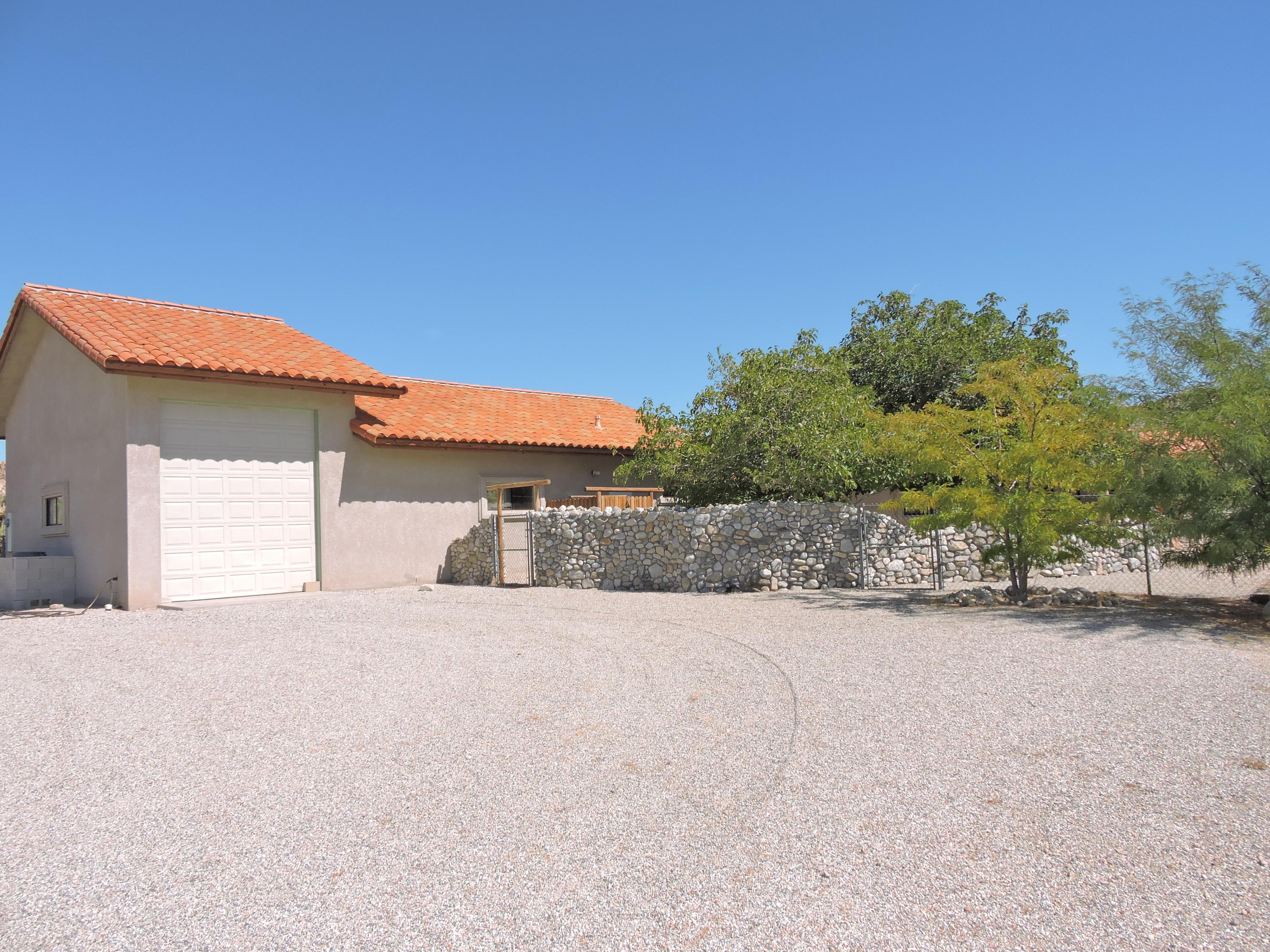 63533 Wagon Wheel Road Joshua Tree, CA 92252 - Photo 7 of 62 a front view of a house with a yard and garage