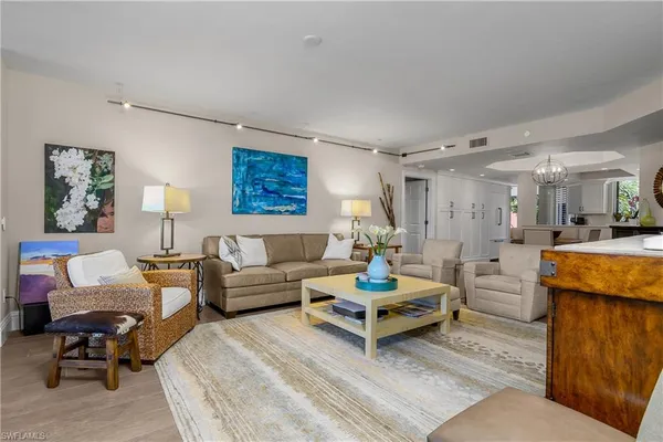 a living room with furniture kitchen view and a table