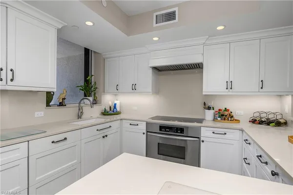 a kitchen with white cabinets and white appliances