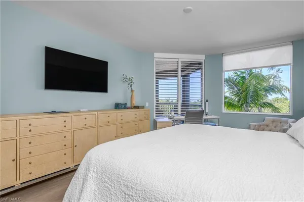 a bedroom with a bed and a flat screen tv