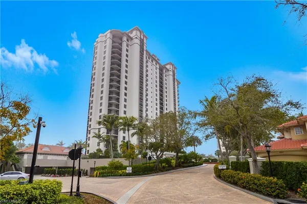 a view of a multi story residential apartment building with a yard