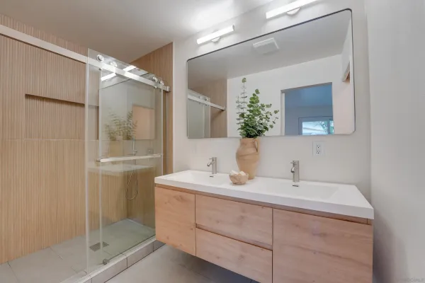 a bathroom with a sink mirror and a shower