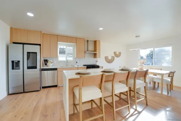 a kitchen with a table chairs refrigerator and window