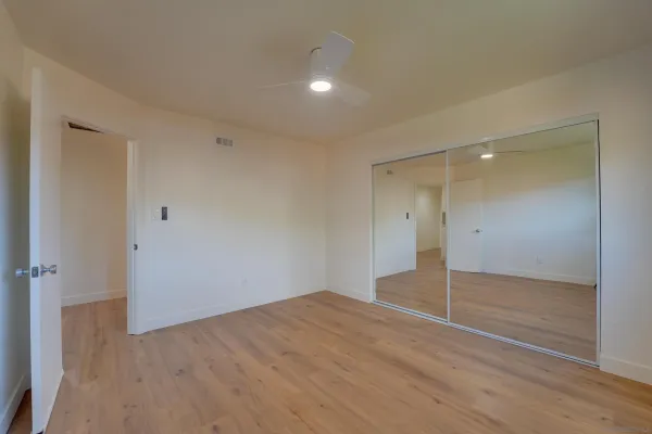a view of empty room with wooden floor