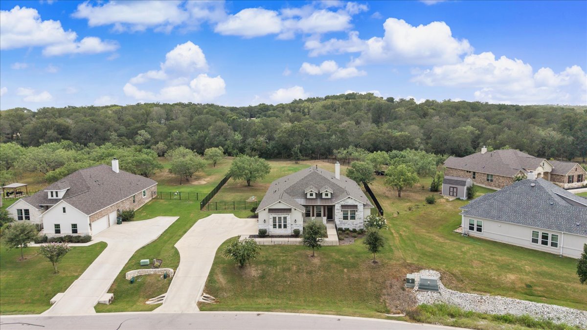 320 Raptor Beak Way Cedar Creek, TX 78612 - Photo 5 of 40 An aerial perspective reveals a private rural estate set against a backdrop of mature trees.