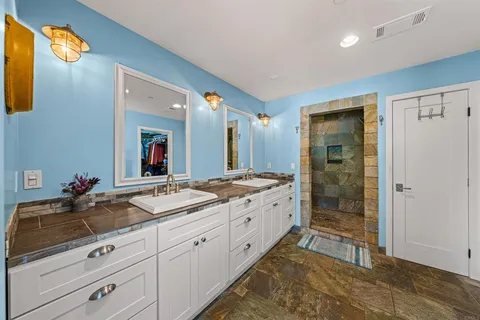 a spacious bathroom with double vanity and a mirror