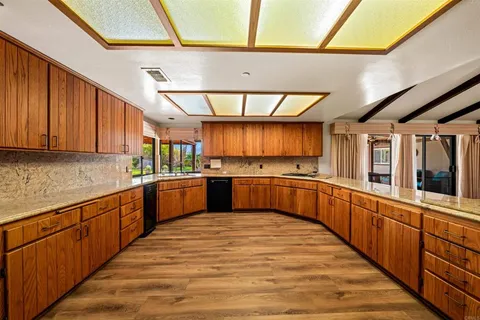 a kitchen with stainless steel appliances wooden cabinets a sink and a stove