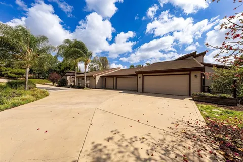 an aerial view of a house with a garden and lake view