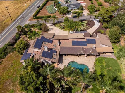 an aerial view of a house with a garden and lake view