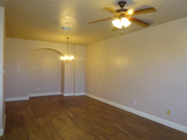 a view of a room with wooden floor and a ceiling fan