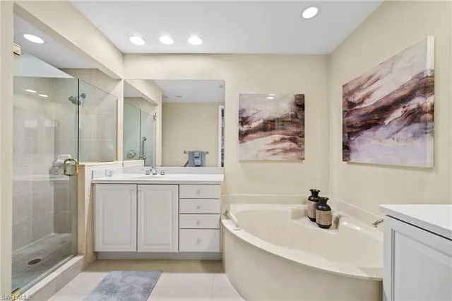a bathroom with a double vanity sink mirror and bathtub