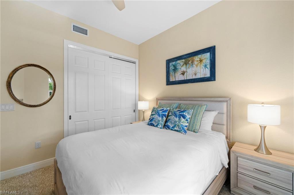7837 Hawthorne Drive, Unit 1101 Naples, FL 34113 - Photo 15 of 41 a bedroom with a bed and a lamp