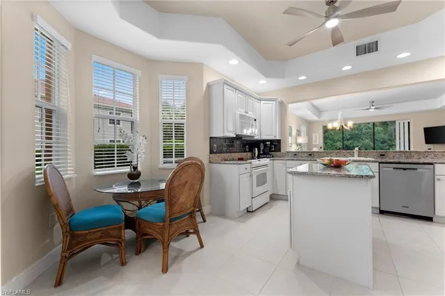 a kitchen with white cabinets and appliances