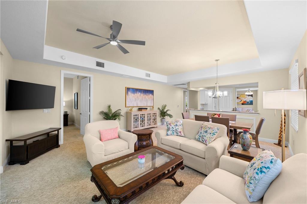 7837 Hawthorne Drive, Unit 1101 Naples, FL 34113 - Photo 25 of 41 a living room with furniture and a flat screen tv