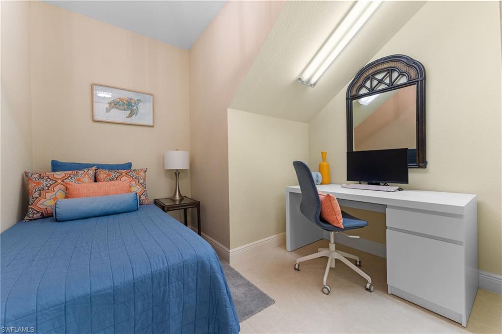 7837 Hawthorne Drive, Unit 1101 Naples, FL 34113 - Photo 27 of 41 a bedroom with a bed a desk and chair