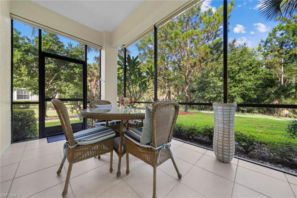 7837 Hawthorne Drive, Unit 1101 Naples, FL 34113 - Photo 31 of 41 a view of a chairs and table in patio with a yard