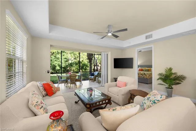 a living room with furniture floor to ceiling window and a flat screen tv
