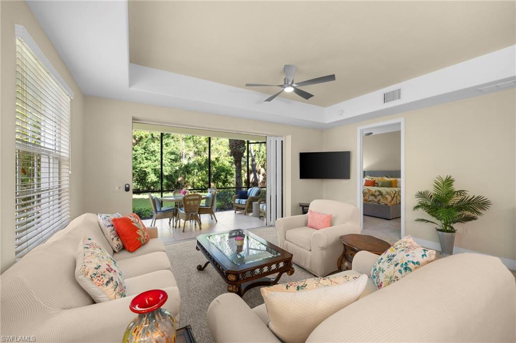 7837 Hawthorne Drive, Unit 1101 Naples, FL 34113 - Photo 7 of 41 a living room with furniture floor to ceiling window and a flat screen tv