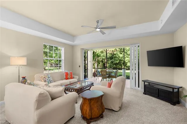 a living room with furniture a flat screen tv and a large window